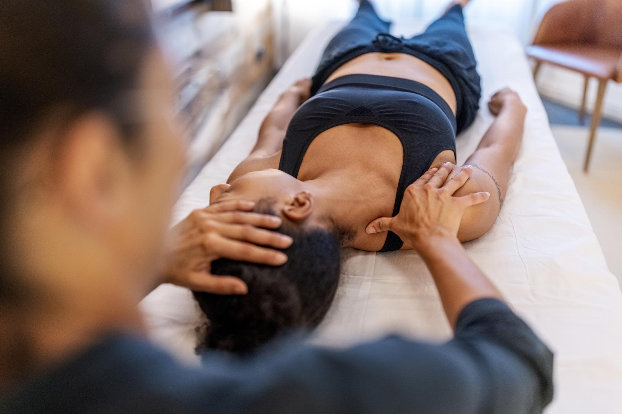 En patient som lider av nacke- och ryggproblem ligger på rygg på en massagebänk